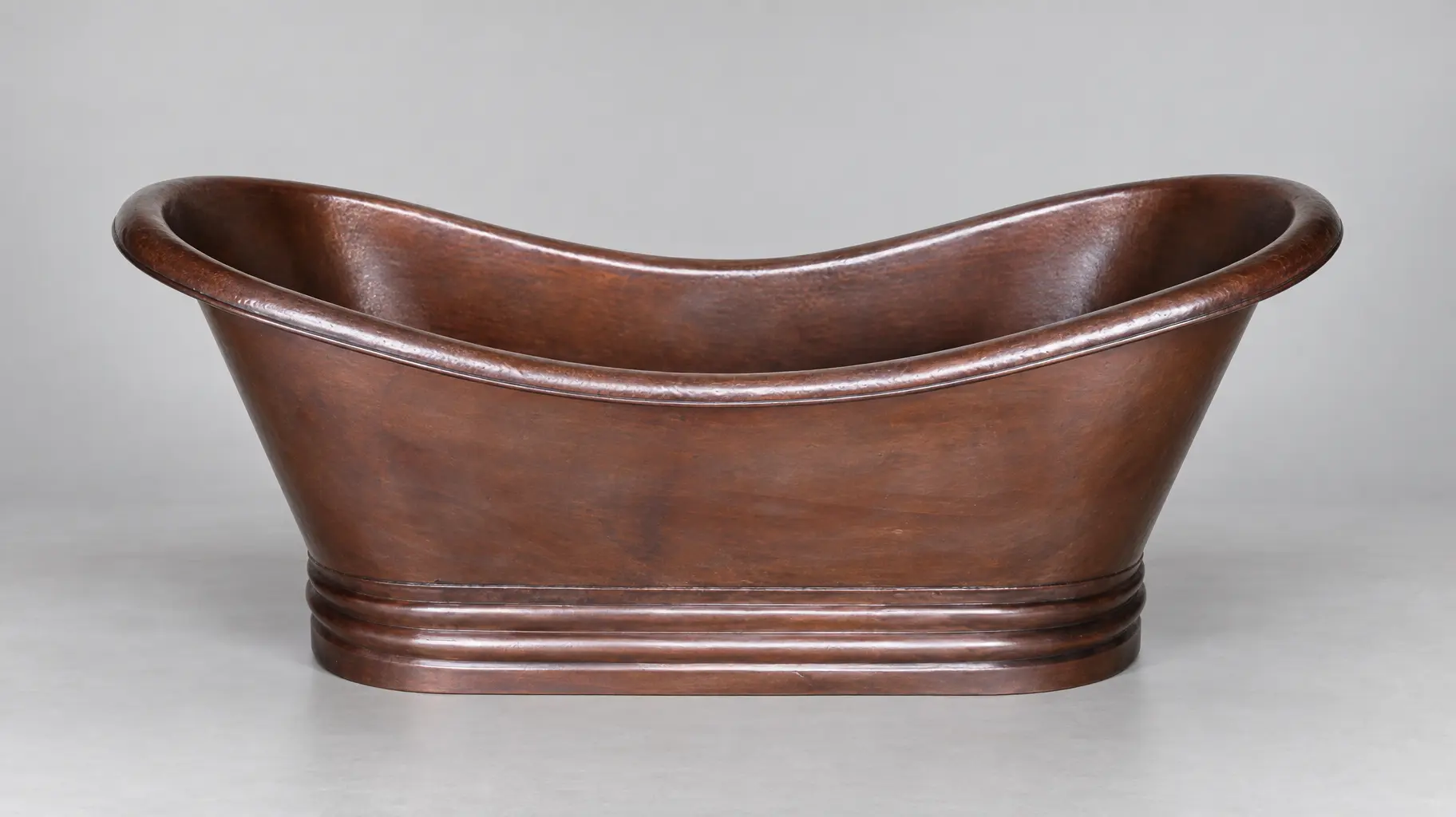 Dark copper bathtub with a rolled rim and plinth